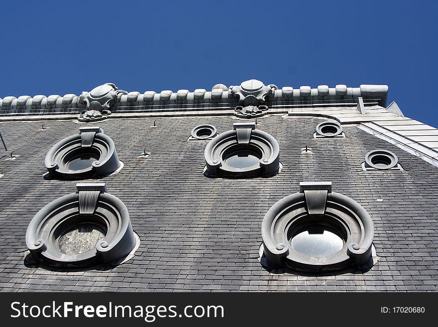 Detail of a typical stone parisian roof with circular skylights, France