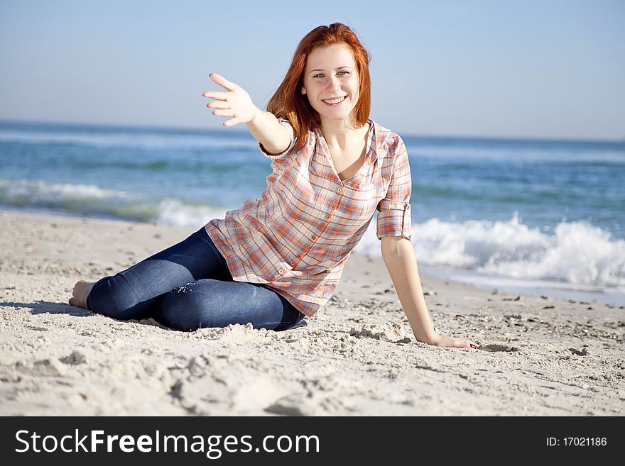 Happy red-haired girl at the beach. Outdoor shot.