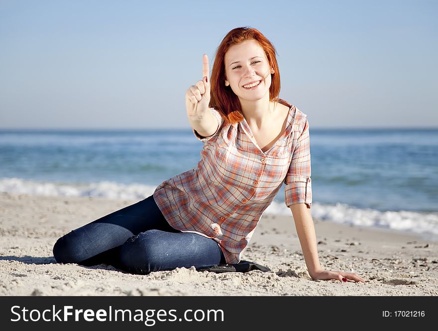 Happy red-haired girl at the beach.