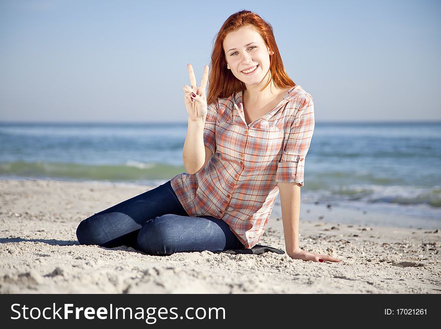 Happy red-haired girl at the beach.