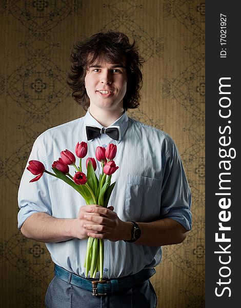 An image of handsome man with red tulips. An image of handsome man with red tulips