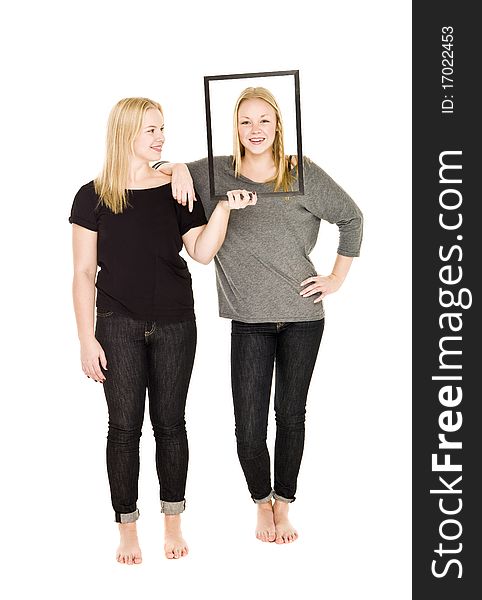 Girl holding a frame in front of her friends face. Girl holding a frame in front of her friends face