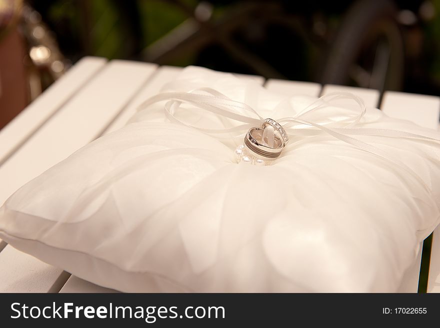 Weddding Ring on Pillow with Ribbon tied in Knot.