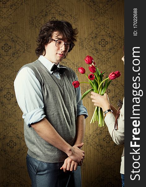 A young man in glasses and red tulips. A young man in glasses and red tulips