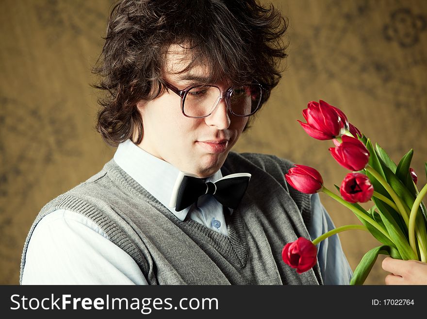 A young man in glasses and red tulips. A young man in glasses and red tulips