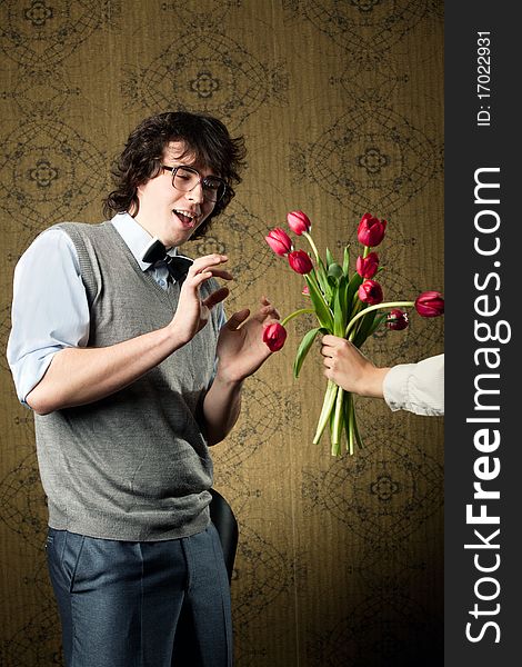 An image of a man in big glasses and red flowers. An image of a man in big glasses and red flowers