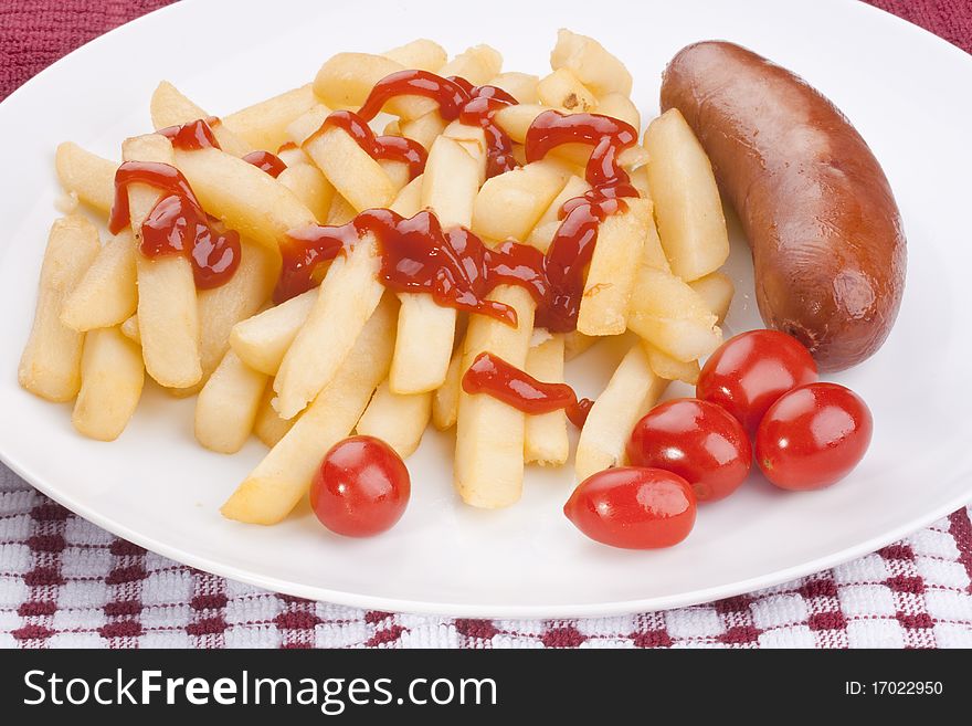 The fried potato is watered by ketchup with sausage and tomatoes.