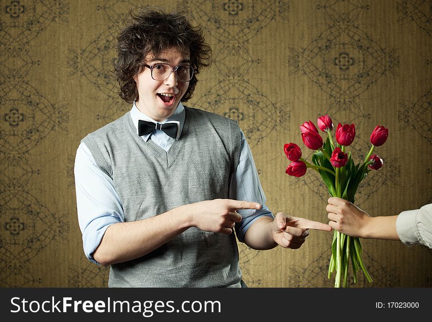 An image of a young man in big glasses and flowers. An image of a young man in big glasses and flowers