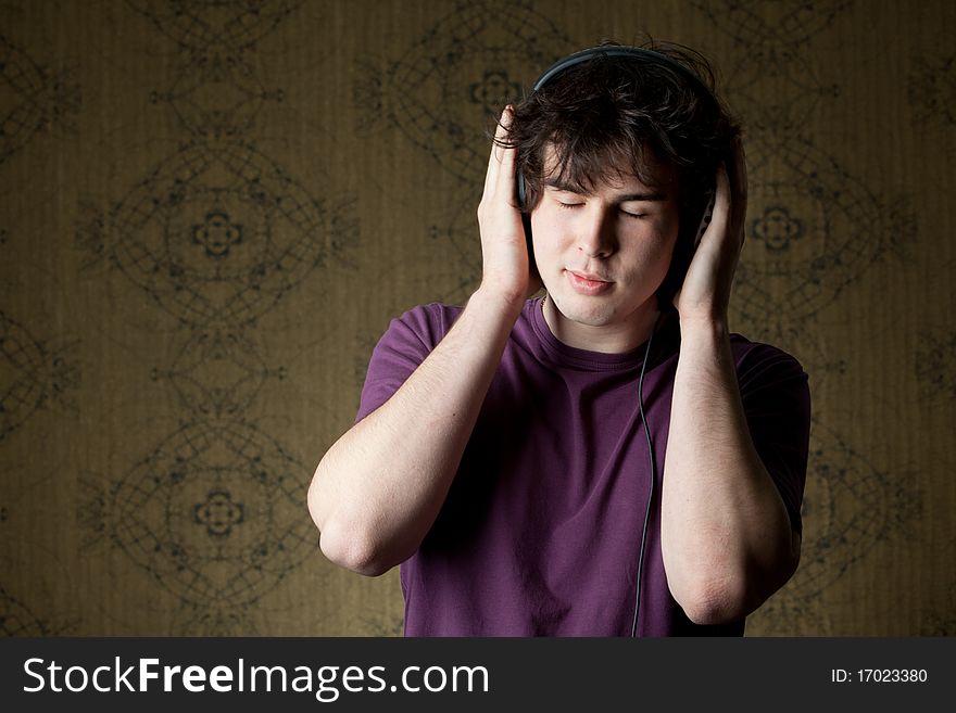 A young man listening to music in headphones. A young man listening to music in headphones