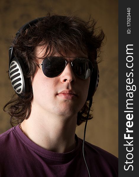 A young man in glasses listening to music in headphones