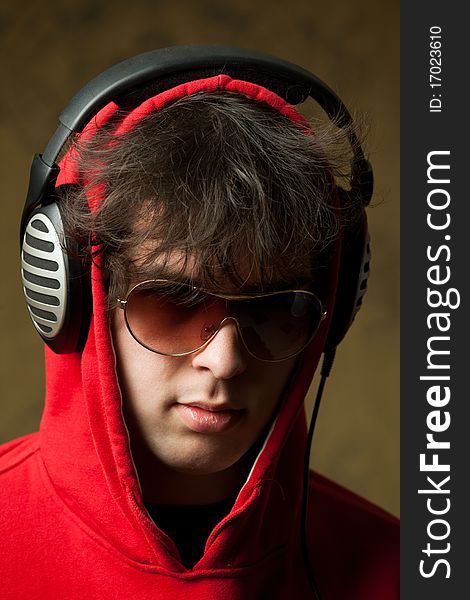 An image of a young man listening to music in headphones. An image of a young man listening to music in headphones