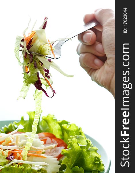 Hand and fork with vegetables salad