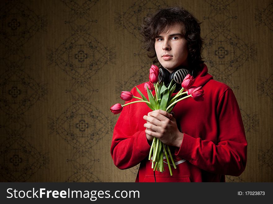 A young man with a bunch of red tulips. A young man with a bunch of red tulips