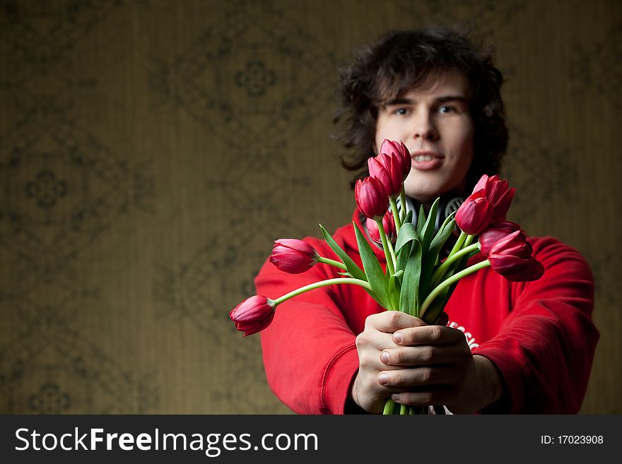 A portrait of a young man with red tulips. A portrait of a young man with red tulips