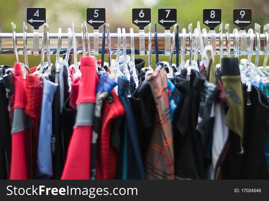 Clothes hanger with clothes of various sizes on clothes rail. Clothes hanger with clothes of various sizes on clothes rail