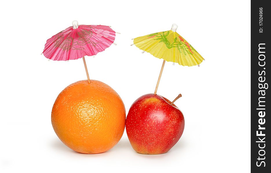 Orange and apple with small paper sunshades on white background. Clipping path included. Orange and apple with small paper sunshades on white background. Clipping path included