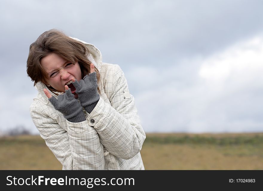 Emotional nice young girl crying on background with autumn dark sky. Emotional nice young girl crying on background with autumn dark sky