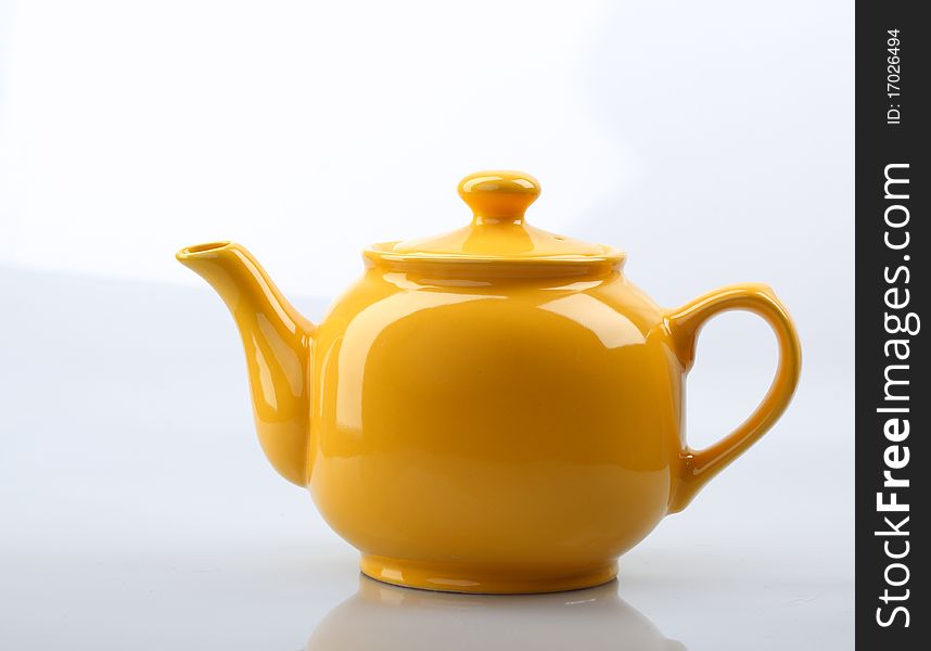 Yellow teapot On a gray background