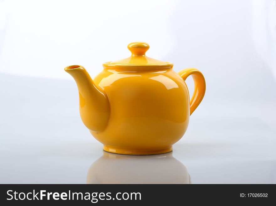 Yellow teapot оn a white background