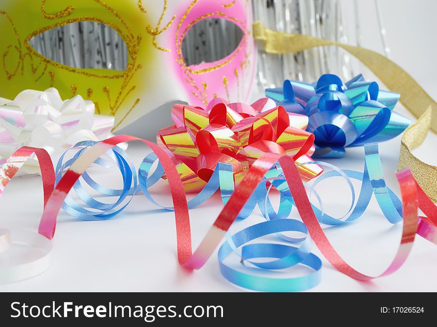 Carnival mask and decorative bows on a white background