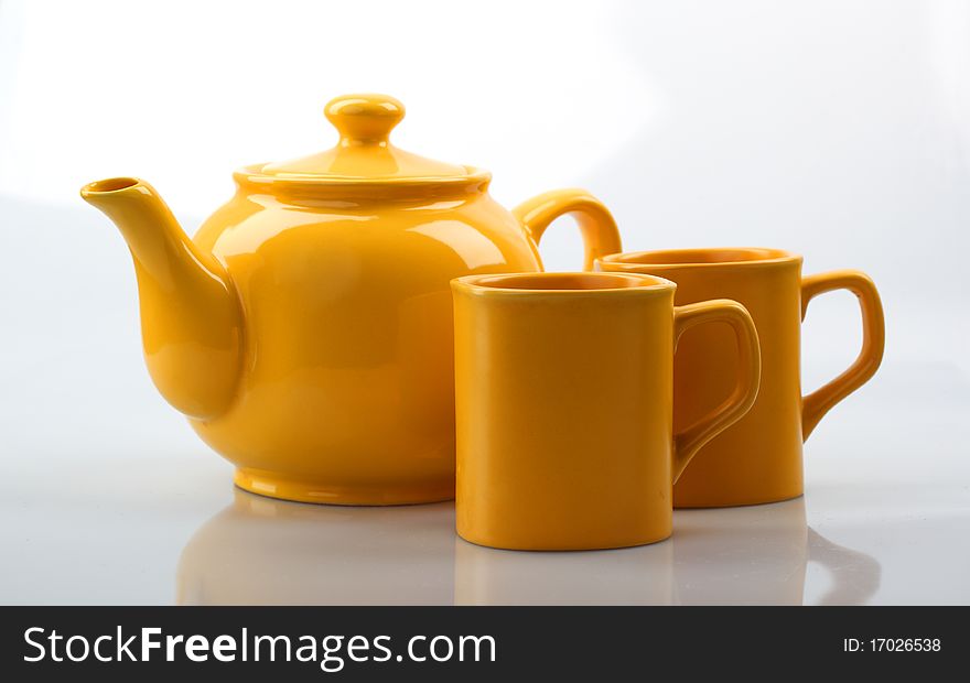 Yellow teapot and mug On a gray background