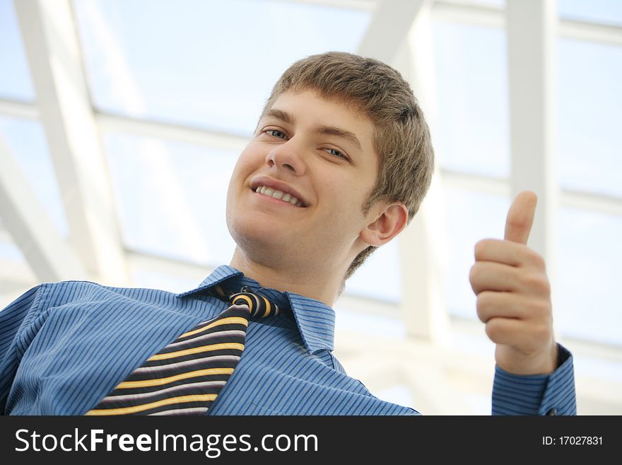 Young businessman thumbs up and smiling