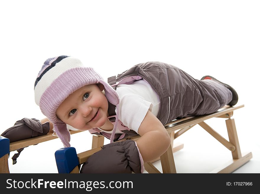 Little girl on sledge is making fun and smiling. Little girl on sledge is making fun and smiling