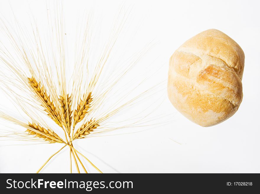 Wheat ears and bread isolated on white