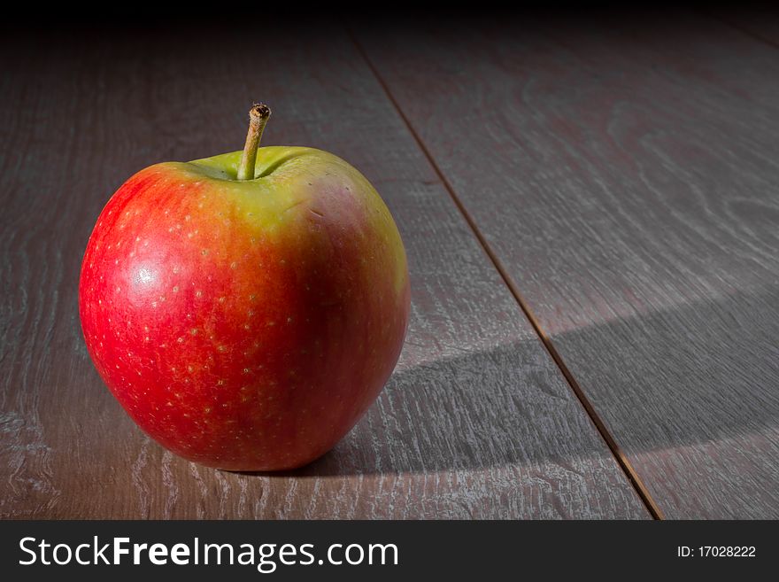 A single apple on a wooden table