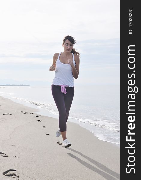 Young healthy woman jogging and running at beach at early morning. Young healthy woman jogging and running at beach at early morning