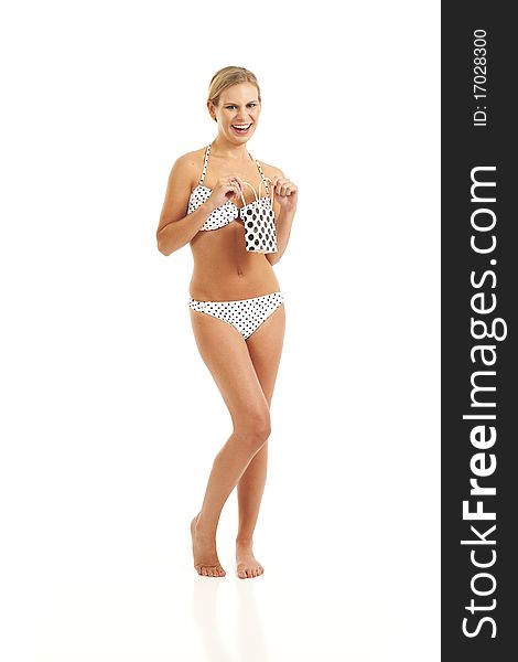 Young woman in white bikini with polka dots holding gift bag. Young woman in white bikini with polka dots holding gift bag