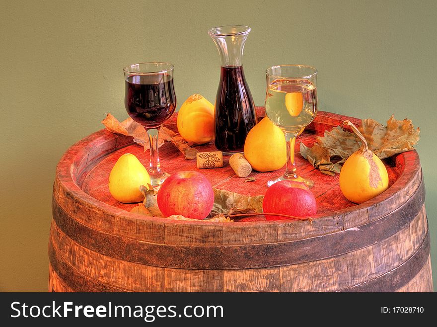Red and white wine on a barrel and some fruits. Red and white wine on a barrel and some fruits