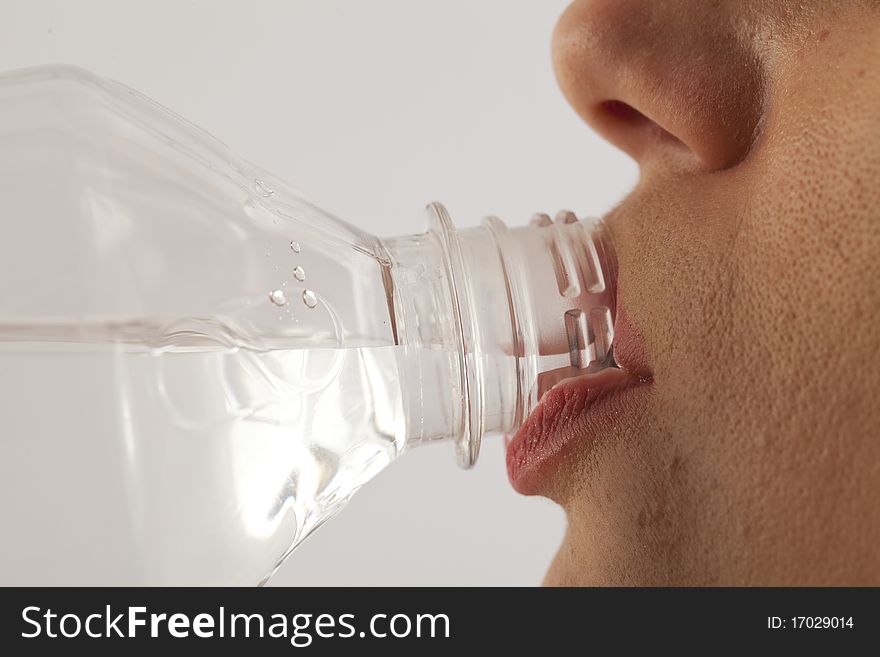 Close up of young woman drinking water from bottle. Close up of young woman drinking water from bottle