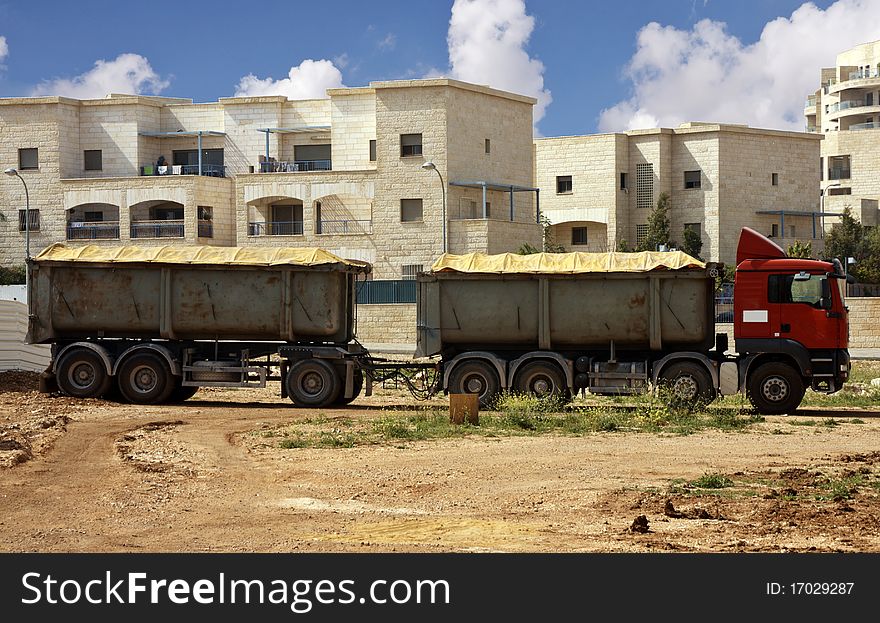 Truck with trailer with buildings as a background