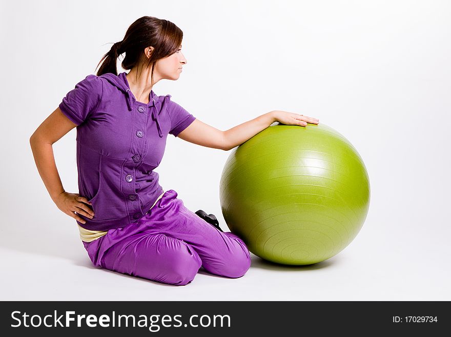 Young beautiful sportswoman standing with a fitness ball. Young beautiful sportswoman standing with a fitness ball