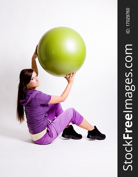Young beautiful sportswoman standing with a fitness ball. Young beautiful sportswoman standing with a fitness ball