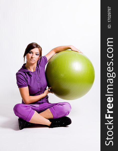 Young beautiful sportswoman standing with a fitness ball. Young beautiful sportswoman standing with a fitness ball