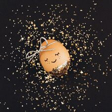 Creative Easter Egg With Cute Face And Sleepy Eyes On Black Background With Golden Glitter Confetti Royalty Free Stock Photos