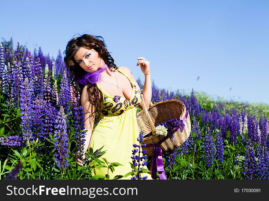Portrait of young woman in plant of violet wild lupine