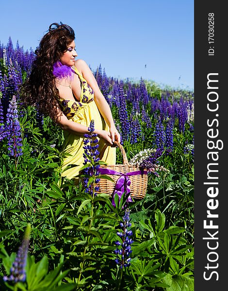 Portrait of young woman in plant of violet wild lupine