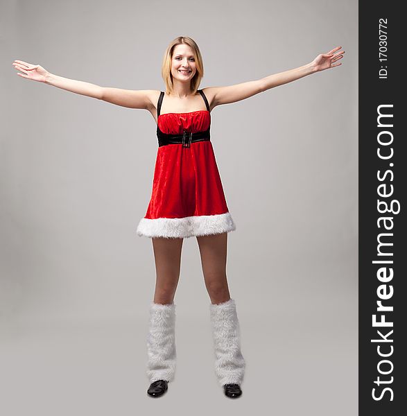 Christmas girl on gray background. Hands up