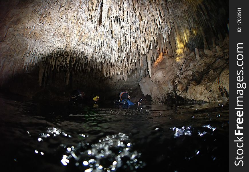 Scubadivers investigate stalactites in an air chamber deep within cenote chac-mool located in the mexican yucatan;. Scubadivers investigate stalactites in an air chamber deep within cenote chac-mool located in the mexican yucatan;