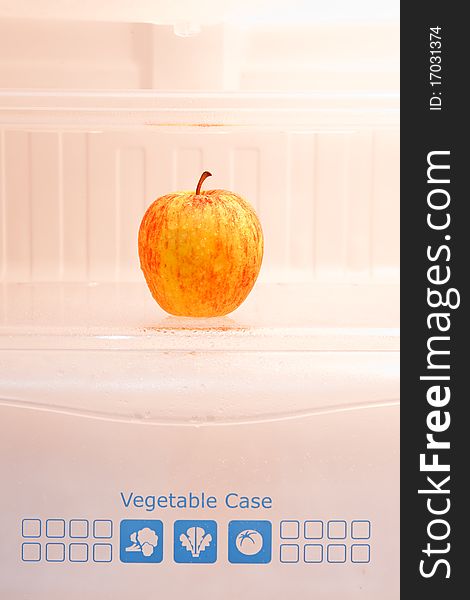 An apple in refrigerator vegetable case