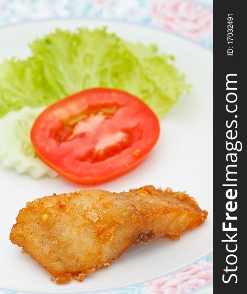 Fried fish and piece of tomato. Fried fish and piece of tomato