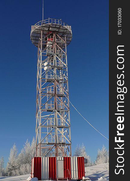 Tower for gantry in a winter snowy forest with dark blue sky as a background. Portrait orientation. Tower for gantry in a winter snowy forest with dark blue sky as a background. Portrait orientation.