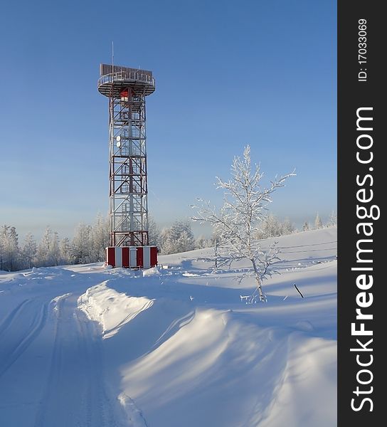 Tower for gantry in a winter snowy forest with dark blue sky as a background. Portrait orientation. Tower for gantry in a winter snowy forest with dark blue sky as a background. Portrait orientation.