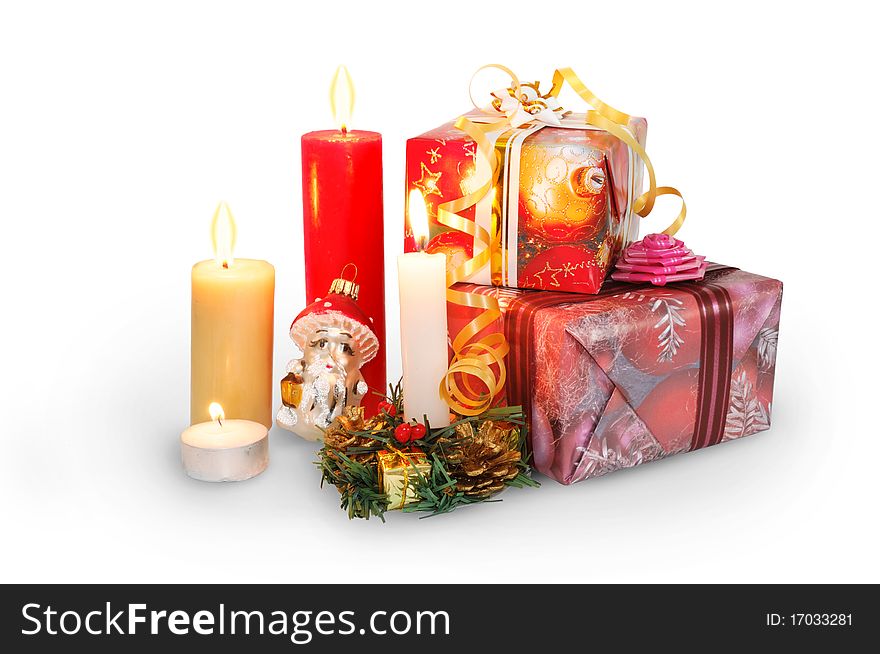 Christmas gifts in the colorful boxes and candles isolated on white. Christmas gifts in the colorful boxes and candles isolated on white