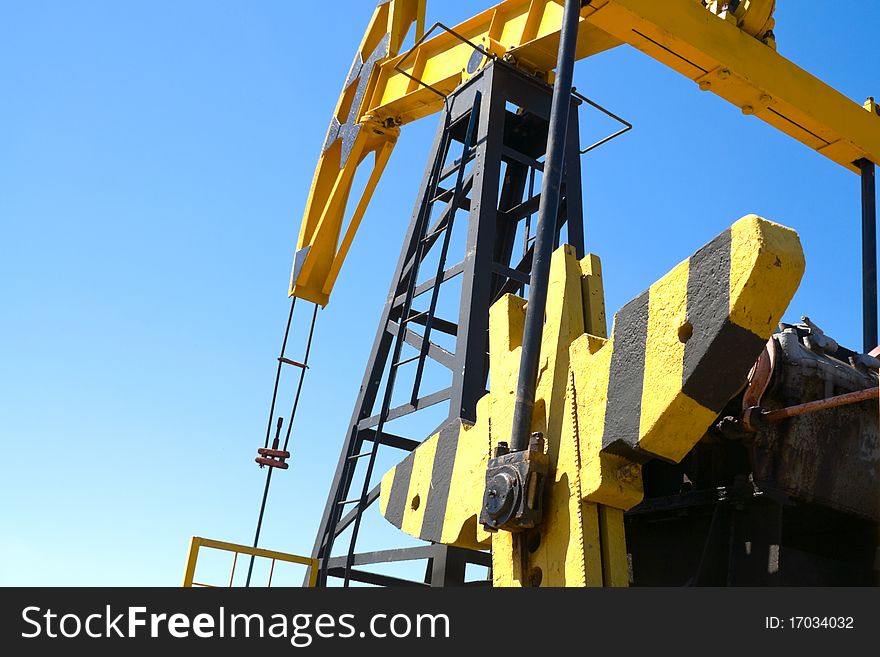 Close-up of oil pump jacks.A pumpjack against blue sky. Close-up of oil pump jacks.A pumpjack against blue sky