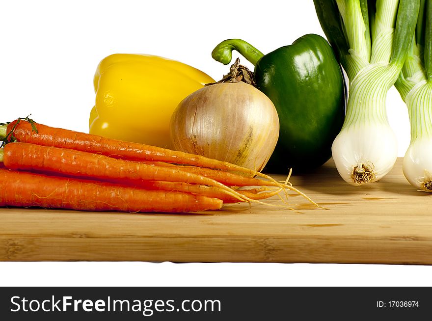 Several vegetables on a wooden cutting board. Several vegetables on a wooden cutting board