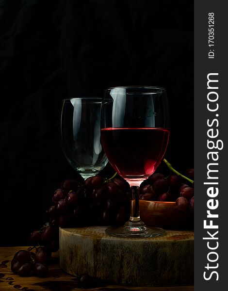 Red Wine And Grapes On Wooden Table